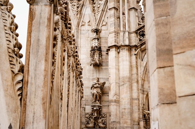 Statua di un nobile in abiti ricchi sulla facciata del duomo italia milano