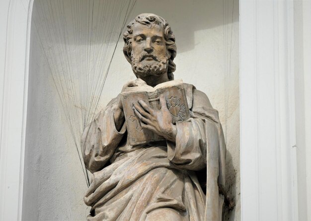 Statua di un santo con libro sulla chiesa cattolica