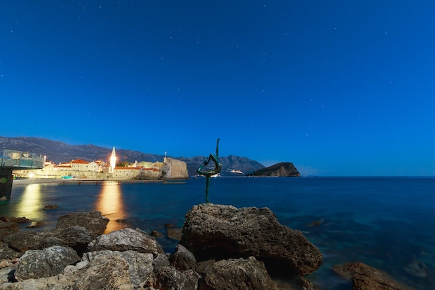 Statua di una ballerina sulla spiaggia nella notte di budva montenegro