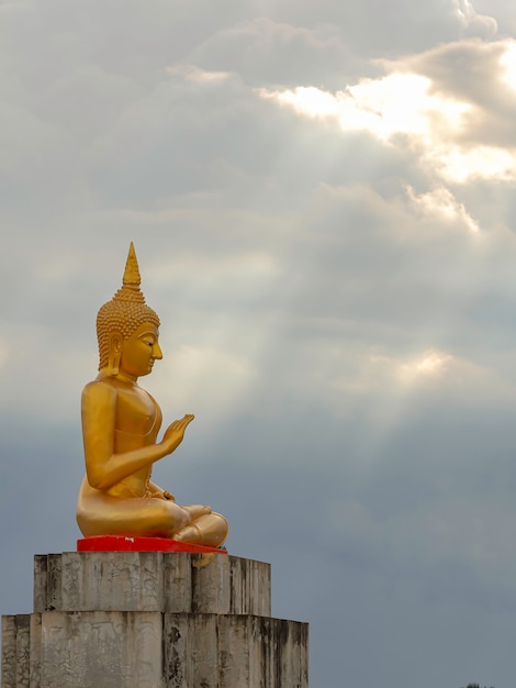 Statua dorata del Buddha con raggio di luce solare