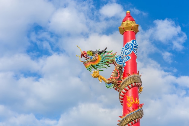 Statua dorata del drago sul palo, Tailandia, drago prominente nel bello sulla priorità bassa del cielo blu