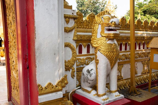 Statua dorata di singha custode della Pagoda o Stupa di Wat Phra That Phanom tempio per viaggiatori stranieri e thailandesi visitano e rispettano pregando a Nakhon Phanom Thailandia