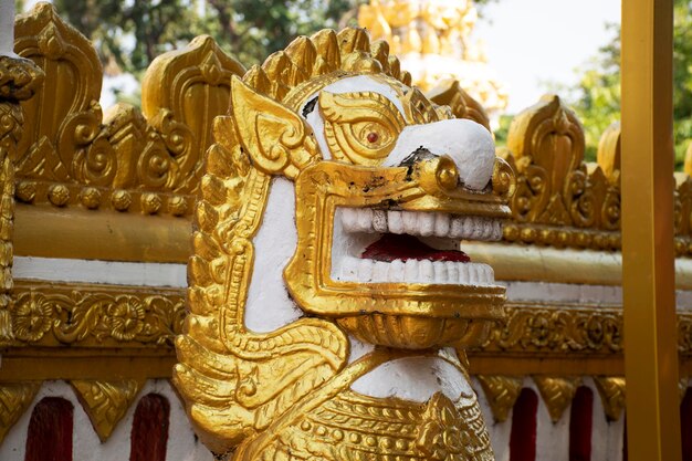 Statua dorata di singha custode della Pagoda o Stupa di Wat Phra That Phanom tempio per viaggiatori stranieri e thailandesi visitano e rispettano pregando a Nakhon Phanom Thailandia