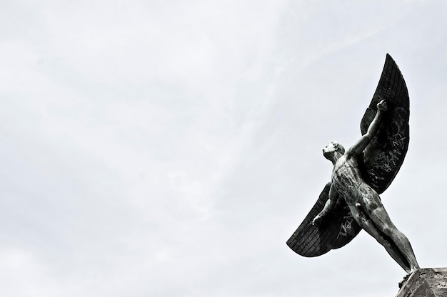 Statua umana alata contro un cielo limpido