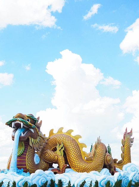 Statua variopinta del drago con cielo blu e nuvole su cielo.