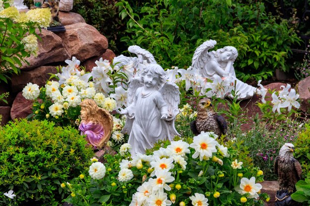 Statue da giardino di angeli e uccelli su aiuola