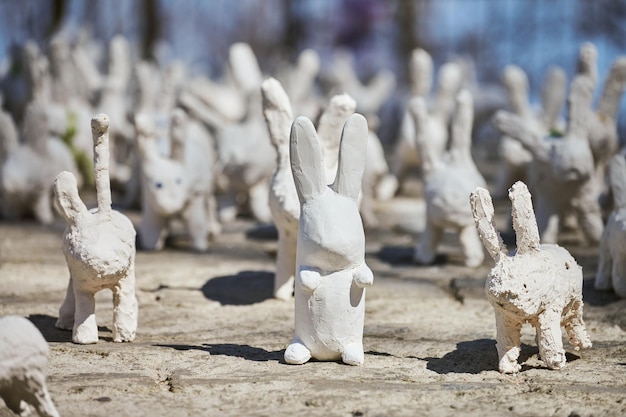 Statue di conigli bianchi in gesso alla mostra d'arte all'aperto divertenti lepri bianche sulla strada