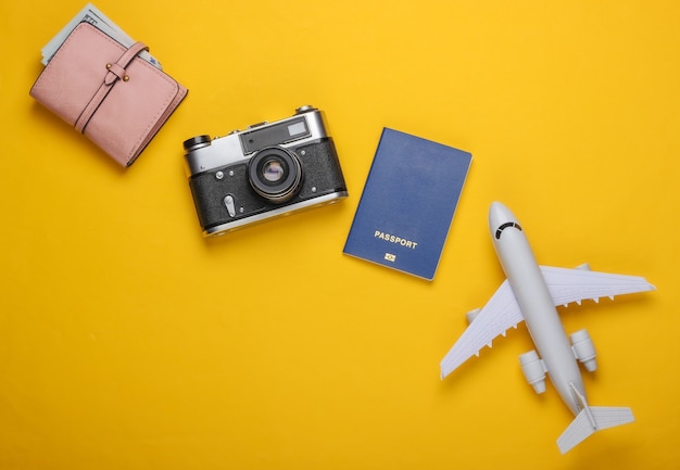 Statuetta FlaPlane, passaporto, portafoglio con dollari, macchina fotografica.