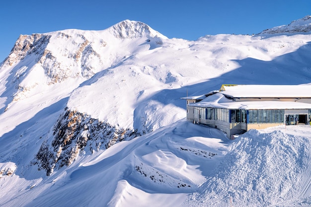 Stazione della funivia sulla stazione sciistica del ghiacciaio di Hintertux in Tirolo a Mayrhofen nella valle Zillertal in Austria nelle Alpi invernali. Seggiovie a Hintertuxer Gletscher in montagna con neve bianca e cielo blu.