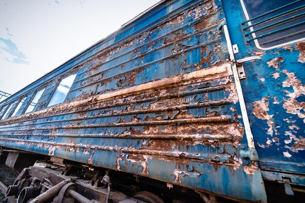 Stazione ferroviaria abbandonata Vernice sbucciata arrugginita di un vecchio carro Carrozza ferroviaria blu Concetto di trasporto