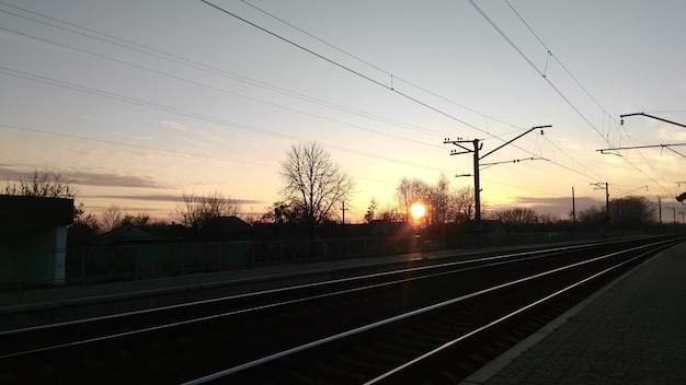 Stazione ferroviaria sullo sfondo di un tramonto soleggiato