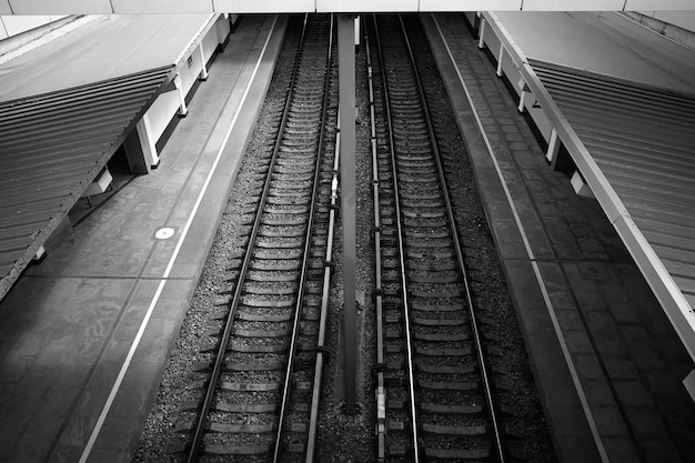 Stazione ferroviaria vuota in bianco e nero con sfondo a due tracce hd