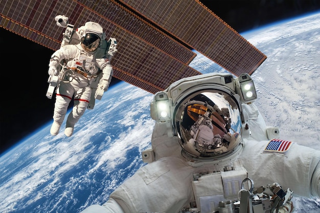 Stazione spaziale internazionale e astronauta nello spazio esterno sul pianeta Terra. Elementi di questa immagine forniti dalla NASA.