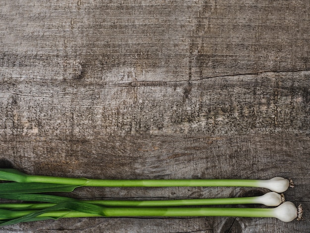 Steli di aglio belli e luminosi su una scrivania non verniciata