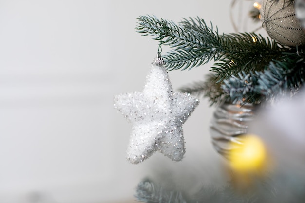 Stella bianca e altre decorazioni sul fuoco selettivo dell'albero di natale