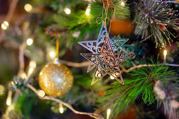 Stella d'oro appesa al ramo dell'albero di Natale. Decorazione per albero di Natale. Preparazione per la vacanza