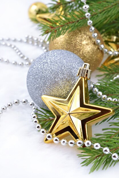 Stella d'oro e palline di Natale su un ramo di abete