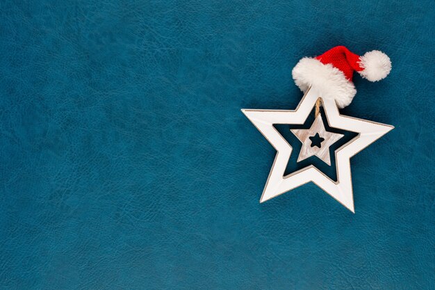 Stella di Natale con decorazione cappello da Babbo Natale. Stella di Natale su sfondo blu.