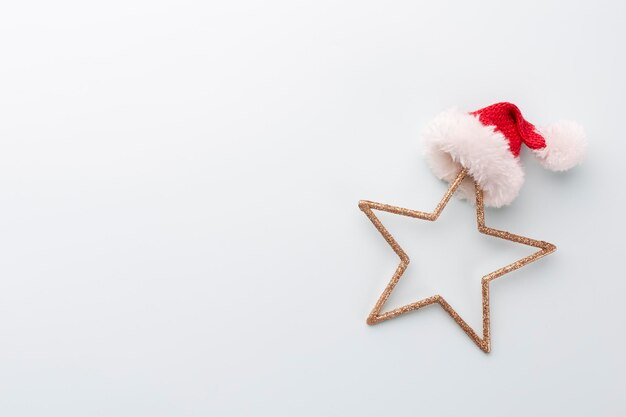 Stella di Natale e cappello da Babbo Natale, decorazioni su sfondo blu pastello.