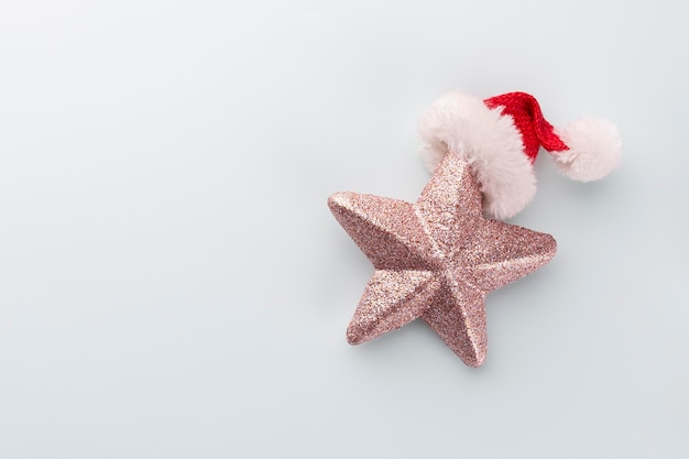 Stella di Natale e cappello da Babbo Natale, decorazioni su sfondo blu pastello.