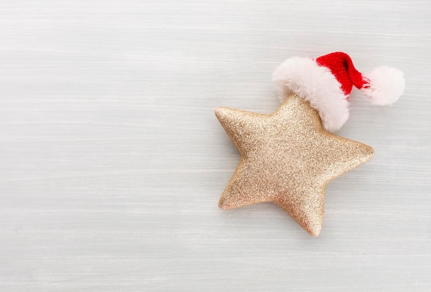 Stella di Natale e cappello di Babbo Natale, decorazioni su fondo di carta.