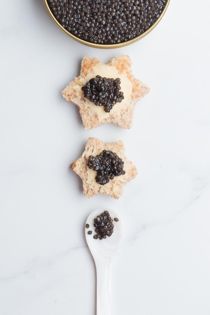 Stella di pane di antipasti di caviale nero su sfondo bianco vista dall'alto