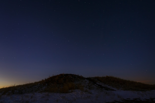 Stelle di notte nel cielo sopra la collina dopo il tramonto.