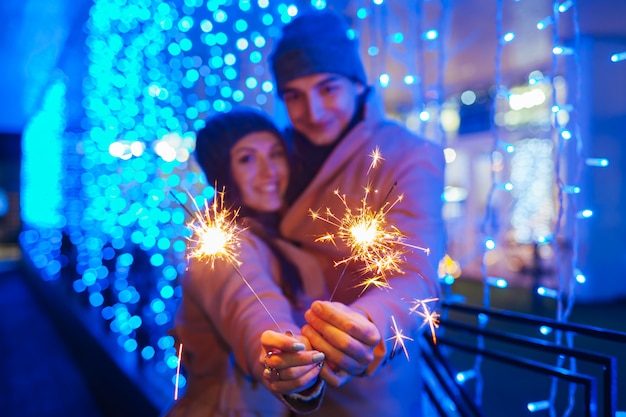 Stelle filante brucianti delle giovani coppie amorose dall'illuminazione di festa