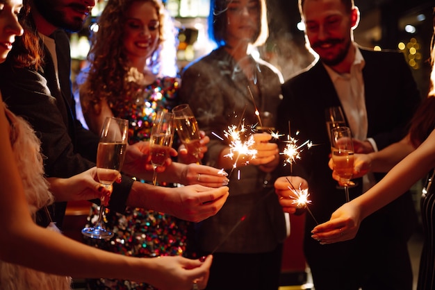 Stelle filanti scintillanti nelle mani. Giocare a fuochi d'artificio per celebrare le vacanze invernali. Magico Anno Nuovo.