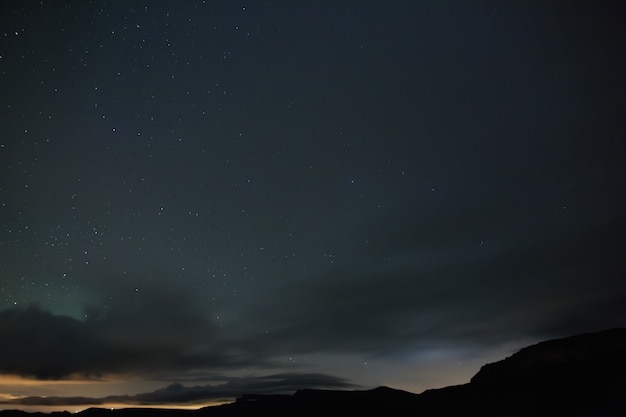 Stelle luminose brillano attraverso le nuvole nel cielo notturno