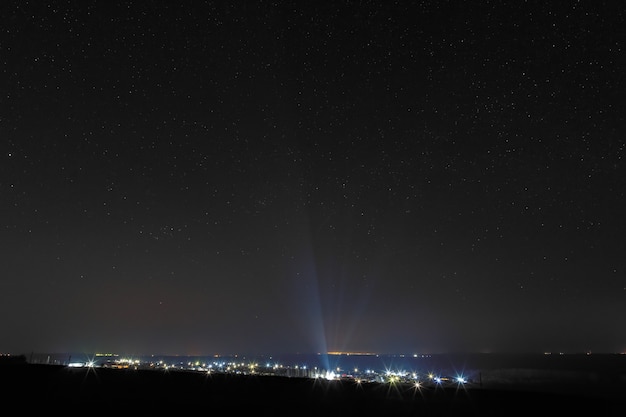 Stelle luminose nel cielo notturno sopra la città. Inquinamento luminoso da lampioni.