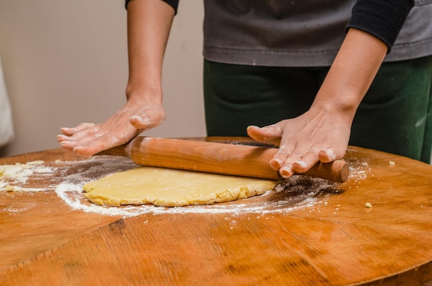 Stendere la pasta biscotto con una scheggia di legno sul tavolo