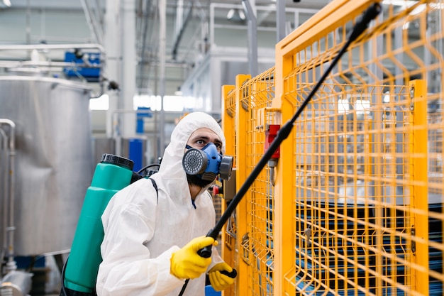 Sterminatore in impianti industriali che spruzzano pesticidi con spruzzatore