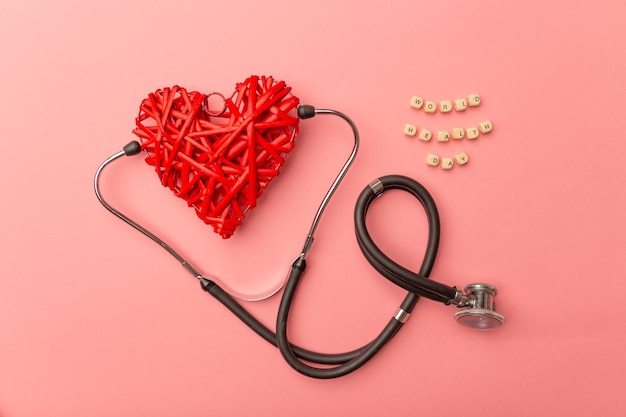 Stetoscopio cuore rosso e testo Giornata mondiale della salute su sfondo rosa Assistenza sanitaria globale