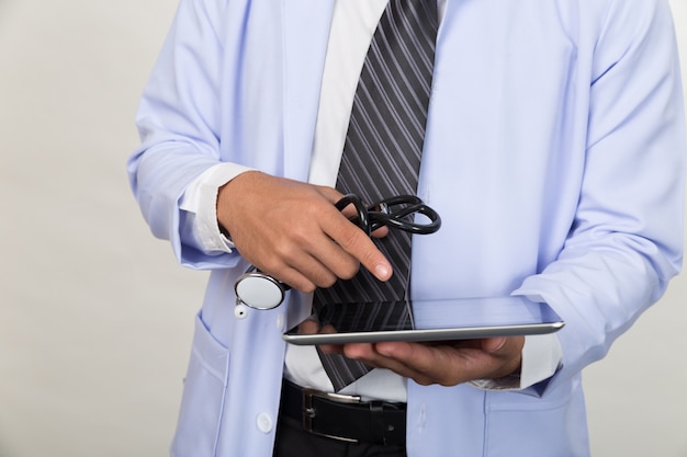 stetoscopio della holding del medico e lavorare con computer tablet moderno