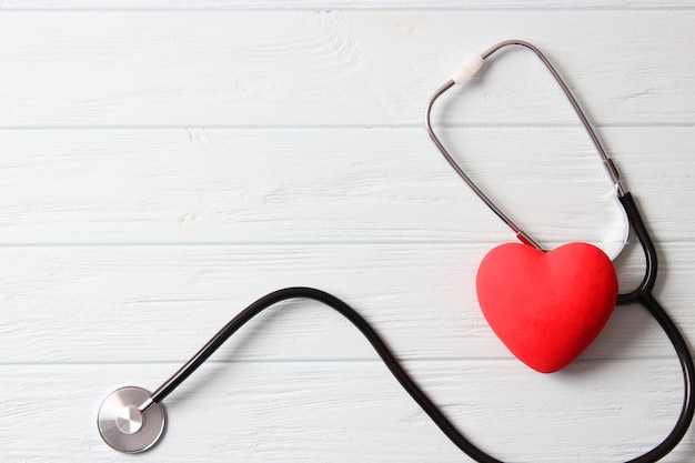 Stetoscopio e cuore su sfondo di colore in legno. Salute, medicina. Foto di alta qualità