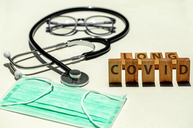 Stetoscopio Occhiali Maschera e blocchi di legno con scritta LONG COVID