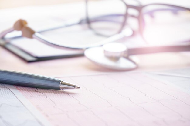 Stetoscopio penna e occhiali sono sul cardiogramma primo piano concetto medico