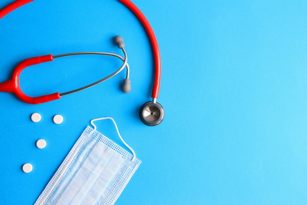 stetoscopio, pillole e maschera medica su sfondo blu concetto di medicina, salute, malattia