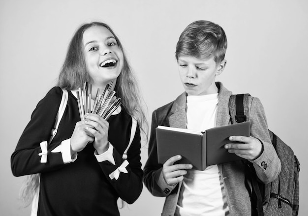 Stiamo scrivendo il nostro futuro Ragazzo e ragazza felici tengono penne e quaderno I bambini piccoli imparano a leggere e scrivere a scuola Imparare le abilità di scrittura nella scuola primaria Migliorare la scrittura calligrafica