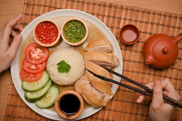 Stile alimentare cinese. Riso al pollo hainanese servito con brodo, ricetta di cibo asiatico. mano e bacchette