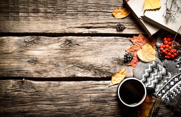 Stile autunnale. Caffè con vecchi libri. Sullo sfondo di legno.