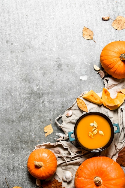 Stile autunnale. Zuppa di zucca da una zucca matura sul tavolo di pietra.