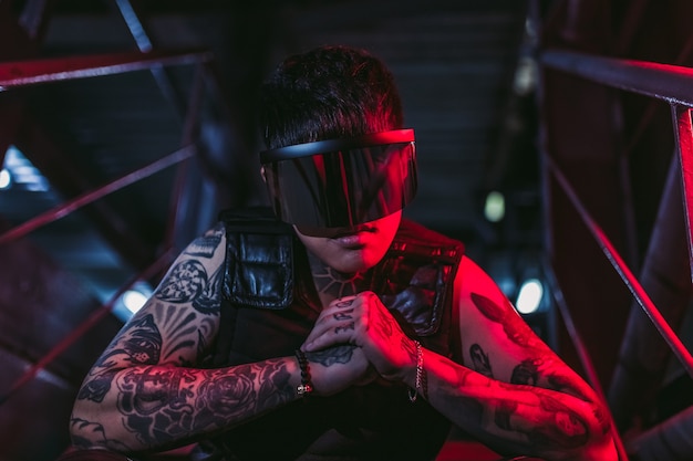 Stile cyberpunk. Ragazzo tatuato in una città. occhiali cyberpunk. Fantasia.