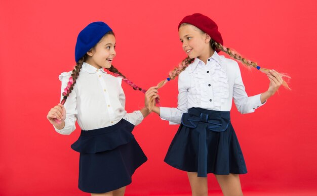 Stile di fantasia Amicizia scolastica Sulla stessa onda Le studentesse indossano l'uniforme scolastica formale Bambini belle ragazze capelli lunghi intrecciati Bambine con trecce pronte per la scuola Concetto di moda scolastica