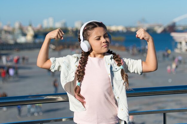 Stile di viaggio libero Emozionanti viaggi attraverso città e musei Guida della città e tour audio Bambina piccola turista esplora la città utilizzando l'applicazione audioguida Gadget per cuffie audio tour