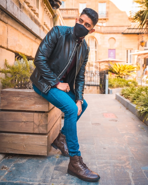 Stile di vita alla moda di un ragazzo latino in città. Jeans, giacca di pelle e scarpe marroni