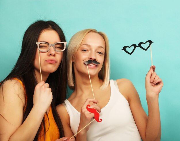 Stile di vita bellezza e concetto di persone Eleganti ragazze sexy hipster migliori amiche pronte per la festa Sfondo blu