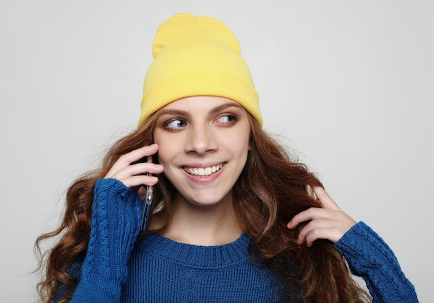 Stile di vita, concetto emotivo e persone. Giovane donna riccia con smart phone