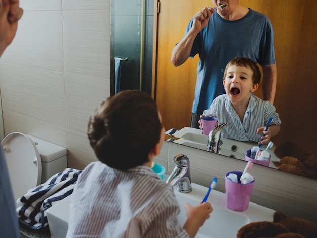 Stile di vita di mattina dello spazzolino da denti di papà figlio